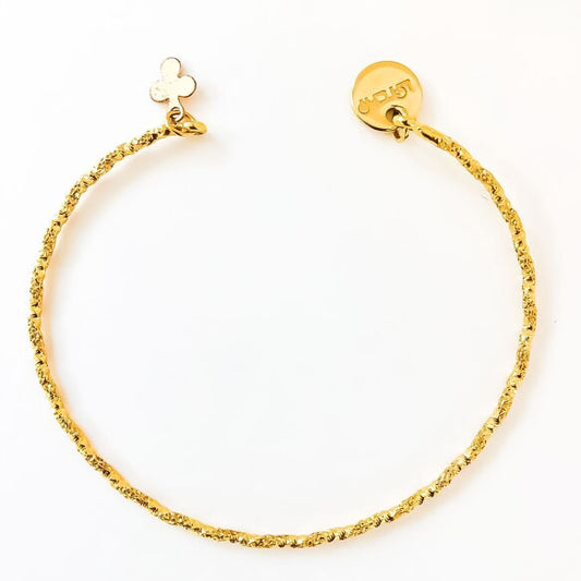 Twisted gilded open bangle bracelet